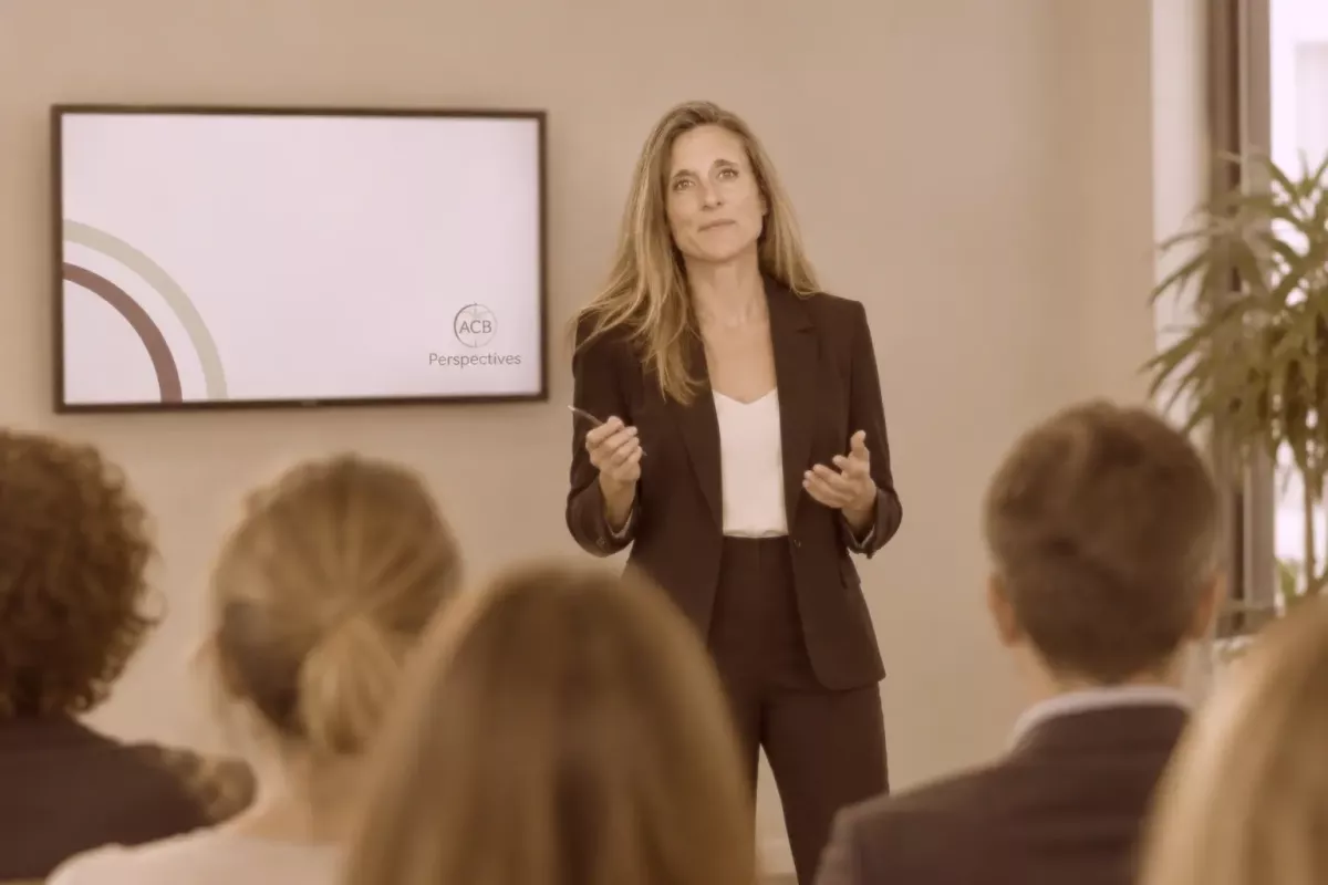 Anne-Célia Bouvier en présentation orale devant un écran où le logo d'ACB-Perspectives est inscrit